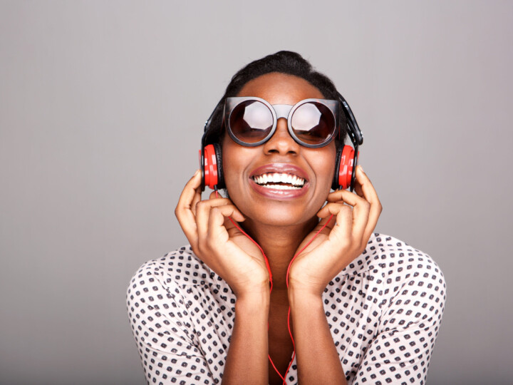 Laughing-woman-with-sunglasses-listening-to-music-on-headphones-1034983438_3869x2579-scaled-uai-